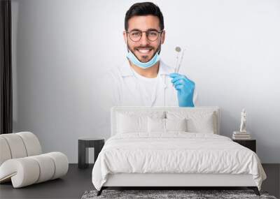 Dentist man holding tools isolated on white background laughing Wall mural