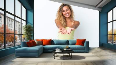 Girl with curly hair isolated on white background holding copyspace imaginary on the palm to insert an ad Wall mural