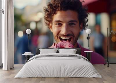 Handsome adult man eating a donut at outdoors Wall mural