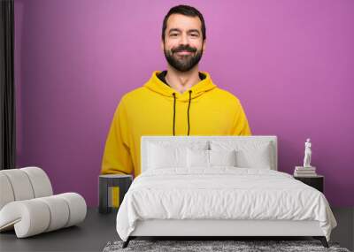 Handsome man with yellow sweatshirt laughing Wall mural