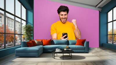 Handsome over isolated purple wall with phone in victory position Wall mural