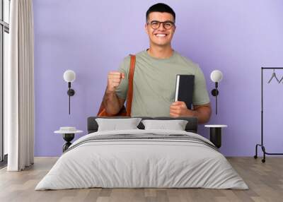 Handsome student man over isolated background celebrating a victory in winner position Wall mural