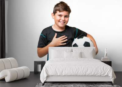 Little caucasian football player kid over isolated chroma key background smiling a lot Wall mural