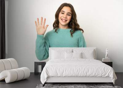 Little caucasian girl isolated on white background saluting with hand with happy expression Wall mural