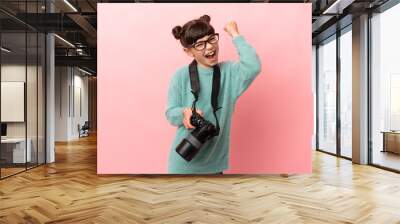 Little photographer girl isolated on pink background celebrating a victory Wall mural