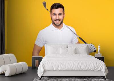 Man over isolated yellow background playing golf Wall mural