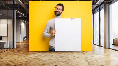 Man with beard and turtleneck holding an empty placard for insert a concept Wall mural