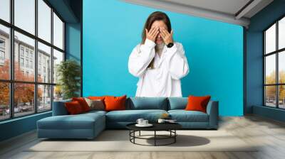 Middle age Brazilian doctor woman isolated on blue background with tired and sick expression Wall mural