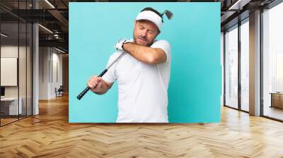 Middle age caucasian golfer player man isolated on blue background suffering from pain in shoulder for having made an effort Wall mural