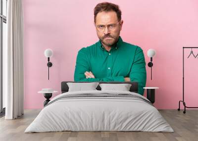 Middle age caucasian man isolated on pink background with unhappy expression Wall mural