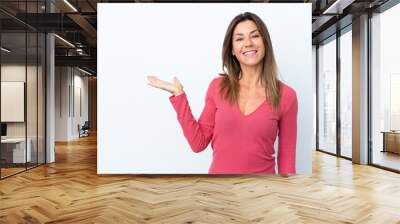 Middle age caucasian woman isolated on white background holding copyspace imaginary on the palm to insert an ad Wall mural