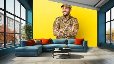 Military man isolated on yellow background happy and smiling Wall mural