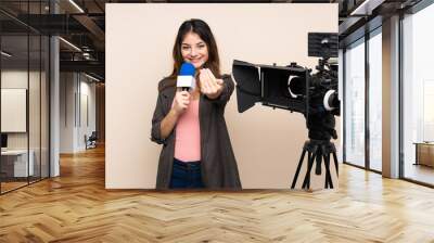 Reporter woman holding a microphone and reporting news over isolated background inviting to come Wall mural