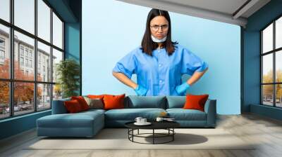 Surgeon woman over isolated blue background angry Wall mural