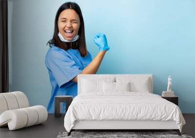 Surgeon woman over isolated blue background celebrating a victory Wall mural