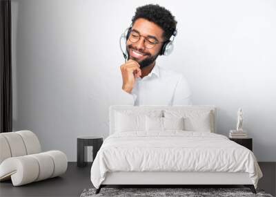 Telemarketer Brazilian man working with a headset isolated on white background looking to the side Wall mural