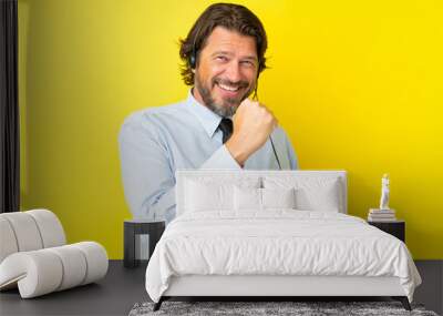 Telemarketer dutch man working with a headset isolated on yellow background celebrating a victory Wall mural