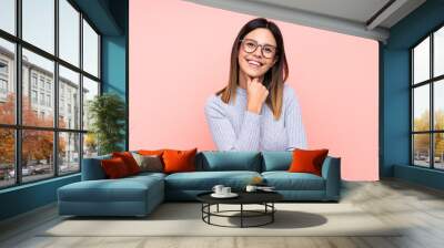 Woman over isolated pink background with glasses and smiling Wall mural