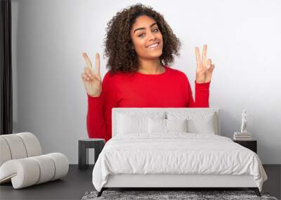 Young African American woman isolated on background showing victory sign with both hands Wall mural