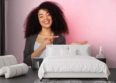 Young african american woman over isolated background holding copyspace imaginary on the palm to insert an ad Wall mural