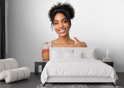 Young african american woman with a cornet ice cream isolated on white background giving a thumbs up gesture Wall mural