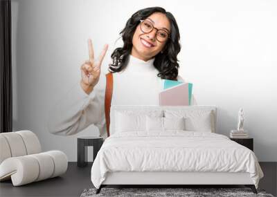 Young Argentinian student woman over isolated background smiling and showing victory sign Wall mural