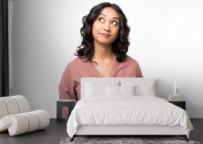 Young Argentinian woman over isolated background and looking up Wall mural