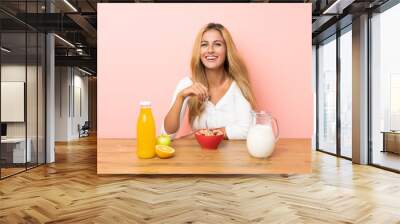 Young blonde woman having breakfast milk Wall mural