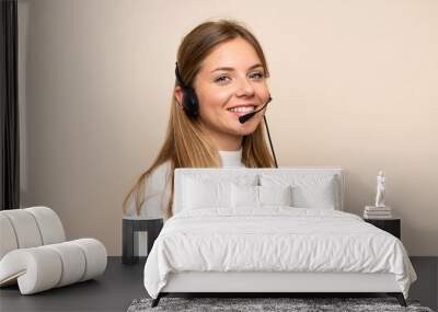 Young blonde woman over isolated background working with headset Wall mural