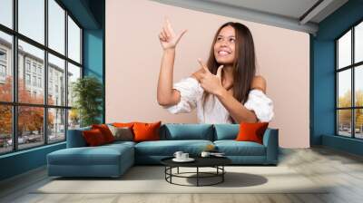 Young Brazilian girl over isolated background pointing with the index finger a great idea Wall mural