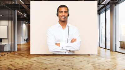 Young brunette man working with a headset smiling a lot Wall mural