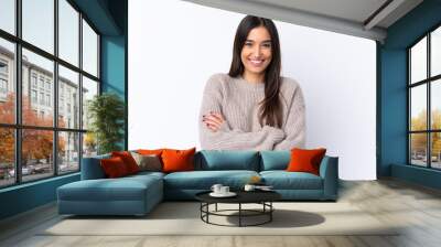 Young brunette woman over isolated white background keeping the arms crossed in frontal position Wall mural