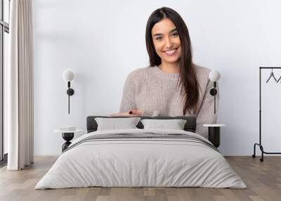 Young brunette woman over isolated white background presenting an idea while looking smiling towards Wall mural