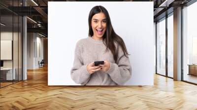 Young brunette woman over isolated white background surprised and sending a message Wall mural