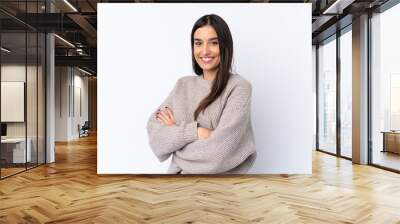 Young brunette woman over isolated white background with arms crossed and looking forward Wall mural