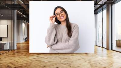 Young brunette woman over isolated white background with glasses and happy Wall mural