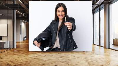 Young brunette woman with a motorcycle helmet and holding a key over isolated white background Wall mural