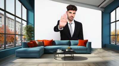 Young businessman over isolated white background making stop gesture with her hand Wall mural