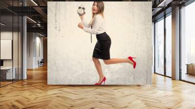 Young businesswoman holding an antique clock over white backgrou Wall mural