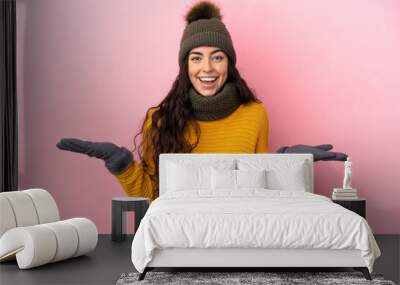 Young caucasian girl with winter hat isolated on purple background with shocked facial expression Wall mural