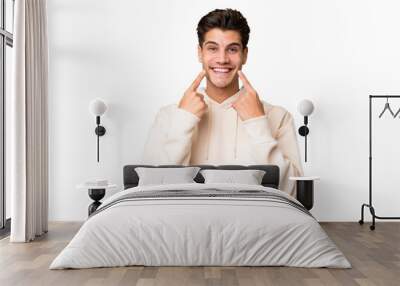 Young caucasian handsome man over isolated background smiling with a happy and pleasant expression Wall mural