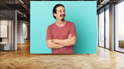 Young caucasian man isolated on blue background happy and smiling Wall mural