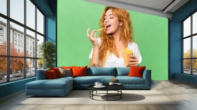 Young caucasian woman holding fried chips isolated on green screen chroma key background Wall mural