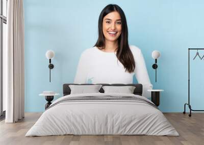 Young caucasian woman isolated on blue background laughing Wall mural