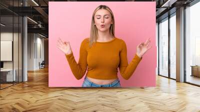 Young caucasian woman isolated on pink background in zen pose Wall mural