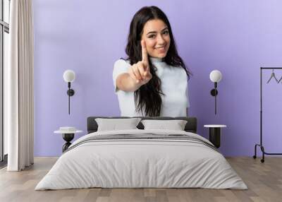 Young caucasian woman isolated on purple background showing and lifting a finger Wall mural