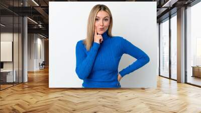 Young caucasian woman isolated on white background and thinking Wall mural