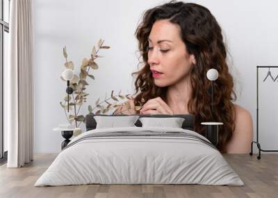 Young caucasian woman isolated on white background holding a eucalyptus branch. Close up portrait Wall mural