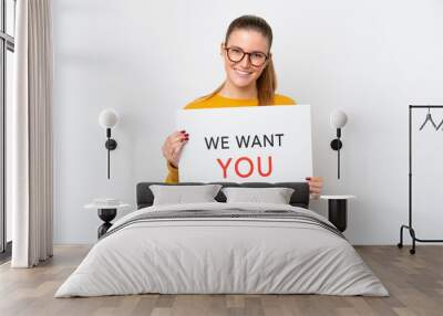 Young caucasian woman isolated on white background holding We Want You board with happy expression Wall mural