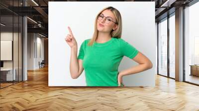 Young caucasian woman isolated on white background showing and lifting a finger in sign of the best Wall mural